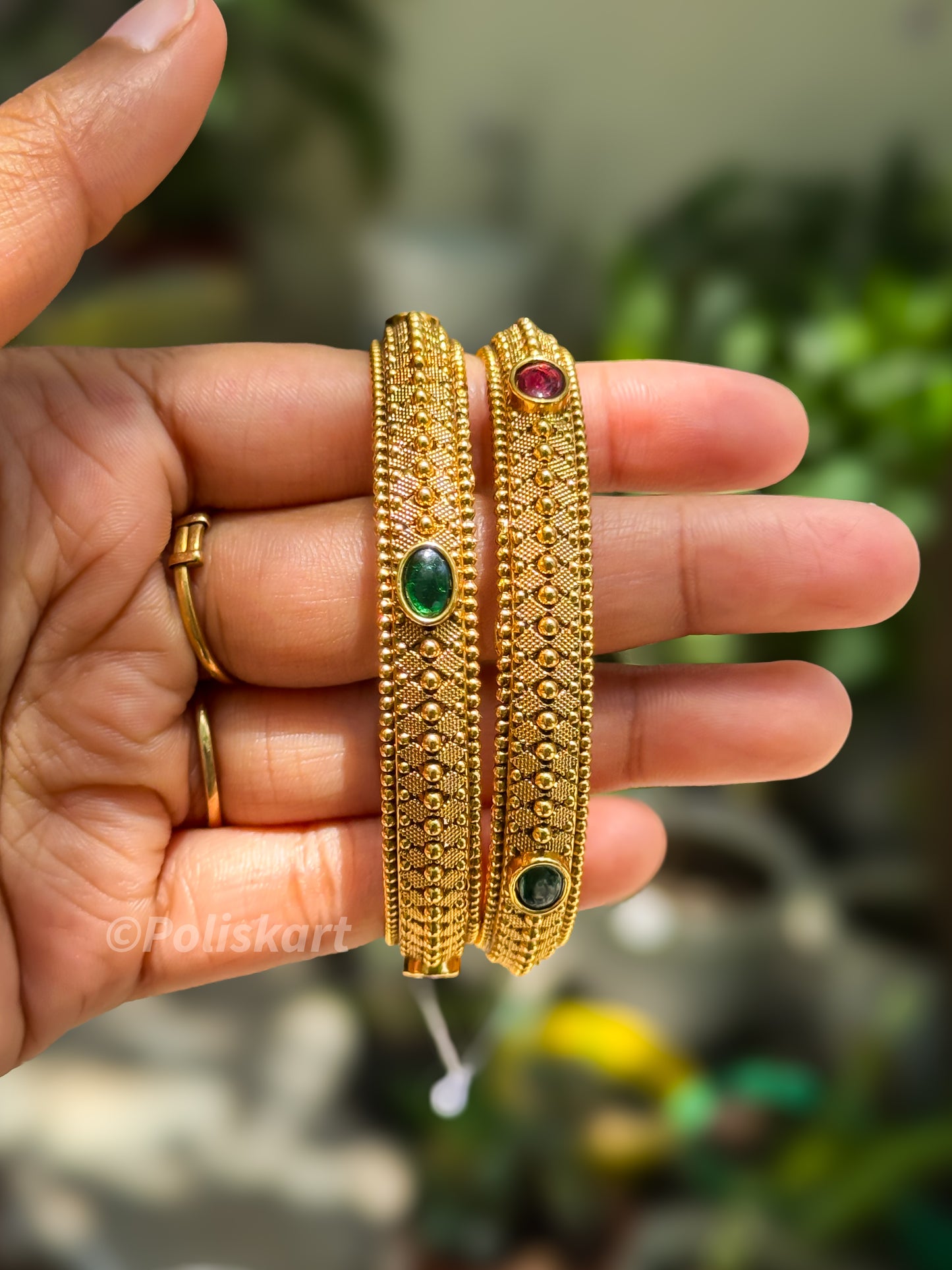 Pair of bangles with rubi and green stone worked design `