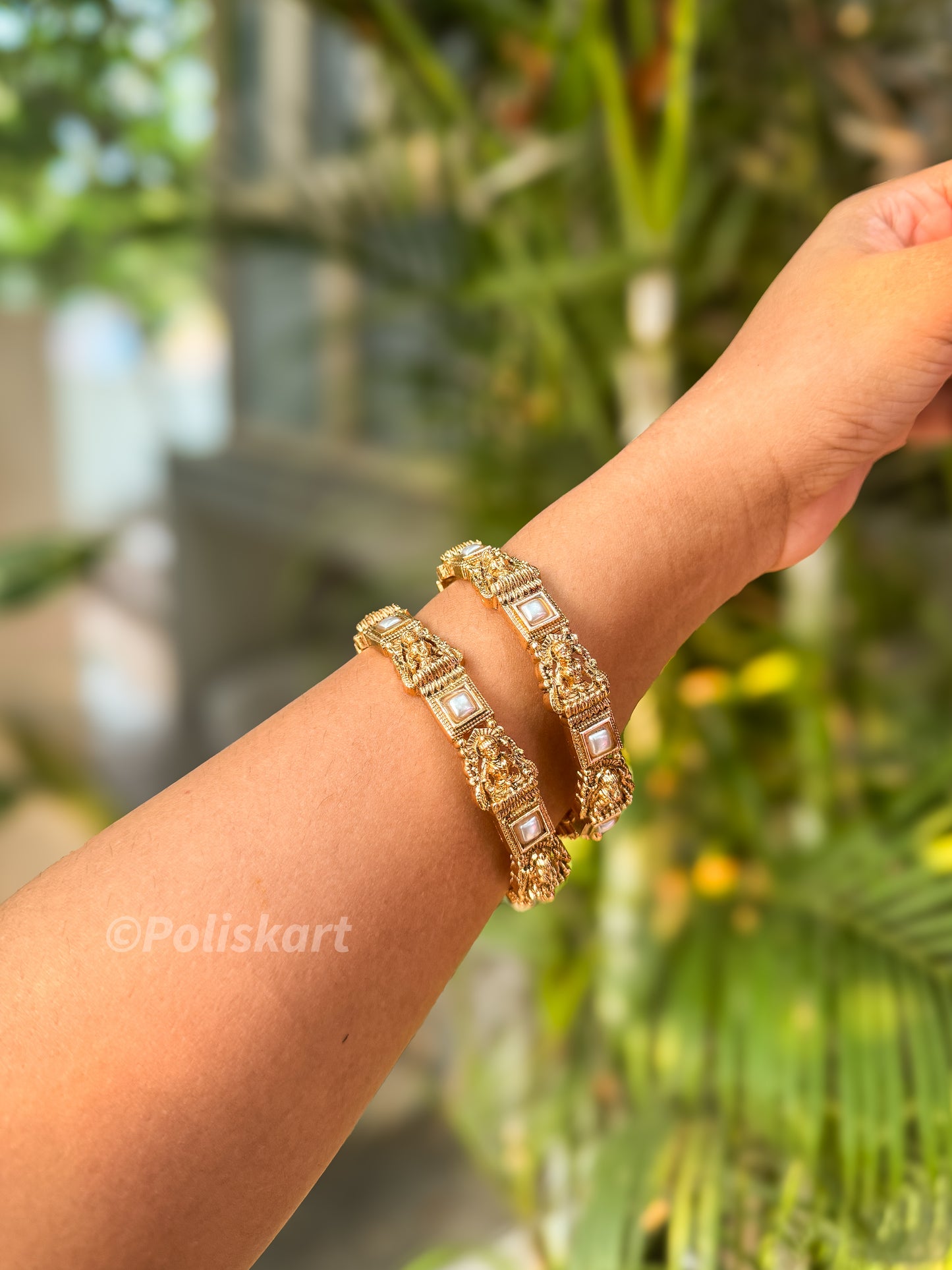 Pair of white pearl and lakshmi worked bangles