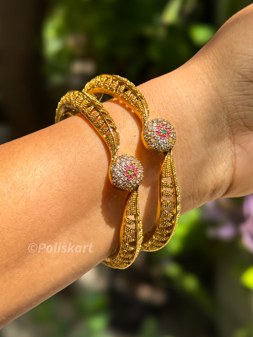 Pair of bangles with rubi and white stone worked design