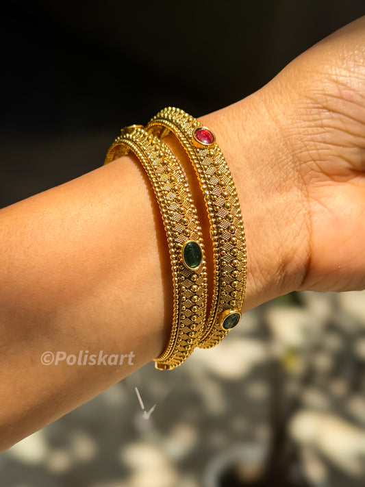 Pair of bangles with rubi and green stone worked design `