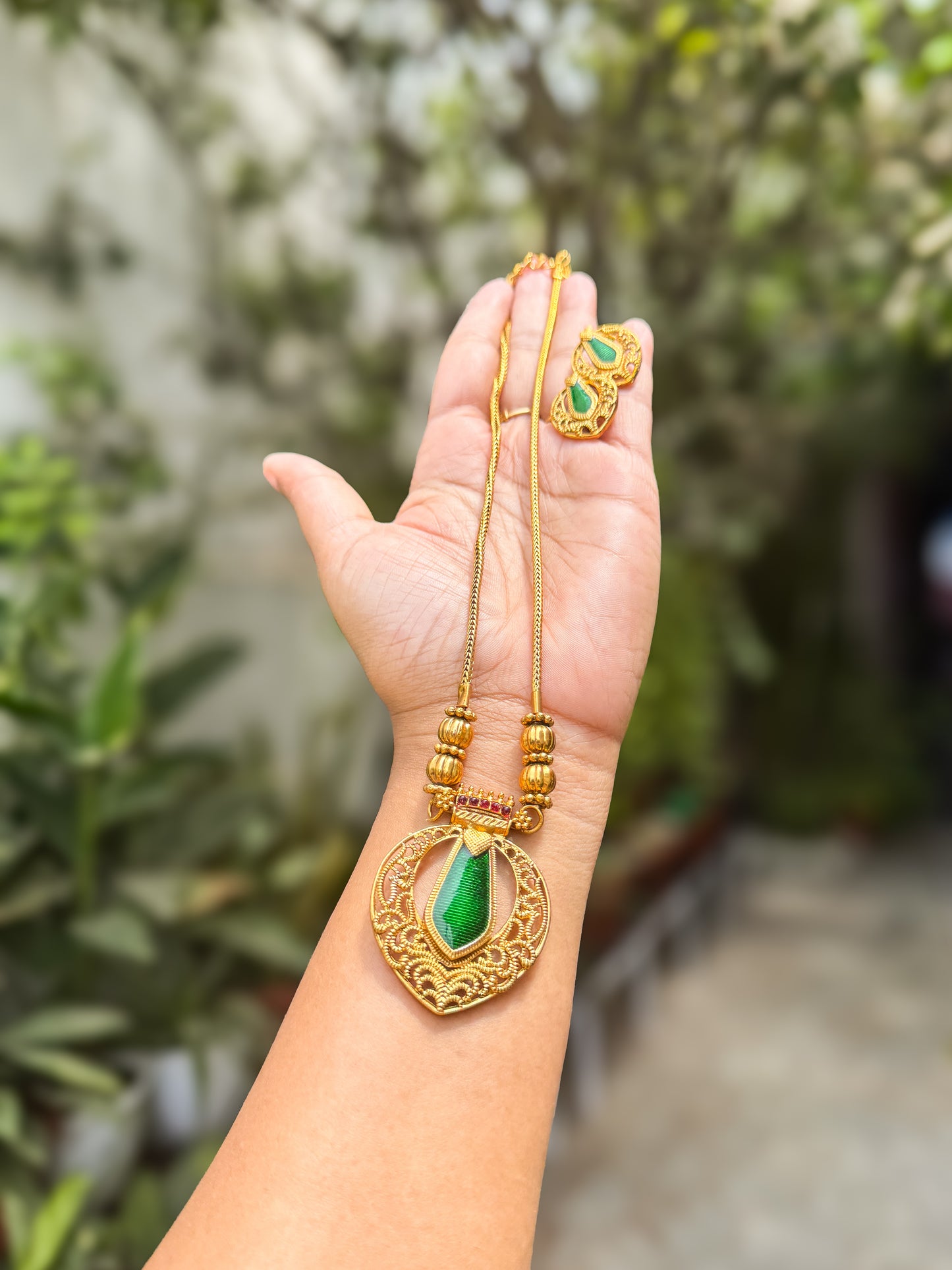 Green stone highlighted pendant with chain and earring set